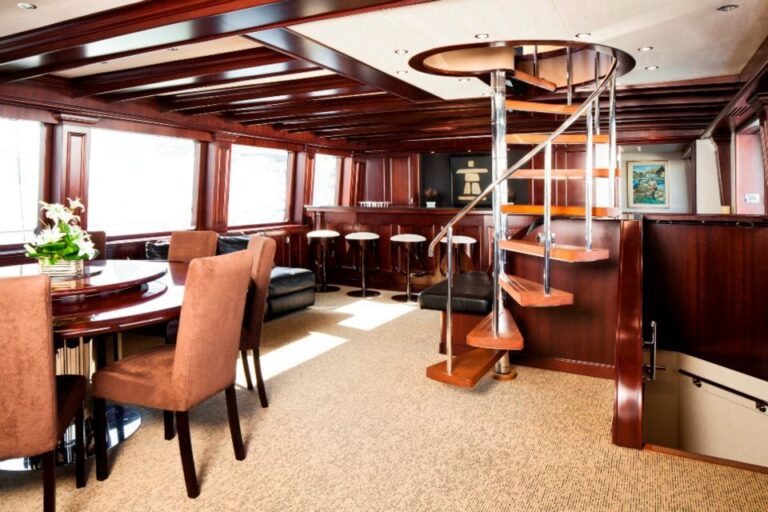 Wood-paneled salon and spiral staircase on the 120' Platinum Marine